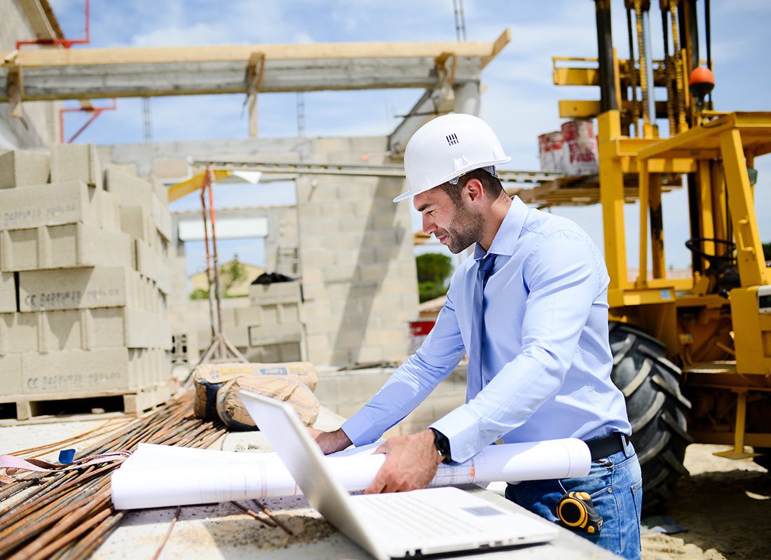 Insurance by Industry - Construction Engineer Examining Site Plans at a Construction Site